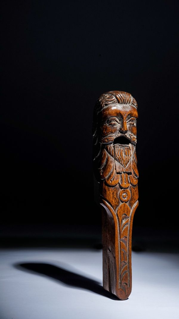 An 18th century novelty nutcracker, carved walnut in the form of a bearded man, 17.5cm high.