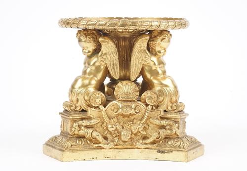 A late 19th century gilt bronze tazza base (lacking top), cast with fruit, swags, shells and three winged cherubs supporting a circular plate, 17.5cm