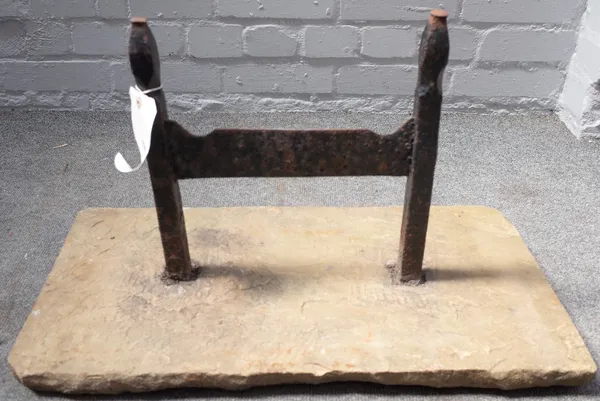 A Victorian cast iron boot scraper with pointed finials, set into a rectangular stone slab, 63.5cm wide.