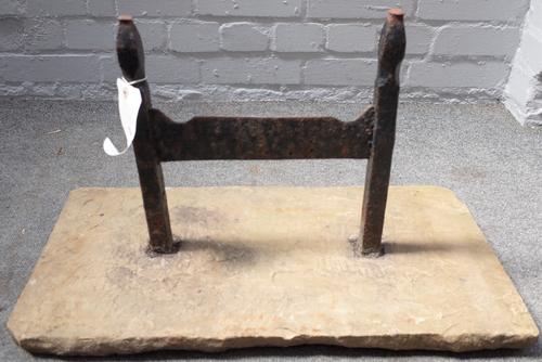 A Victorian cast iron boot scraper with pointed finials, set into a rectangular stone slab, 63.5cm wide.