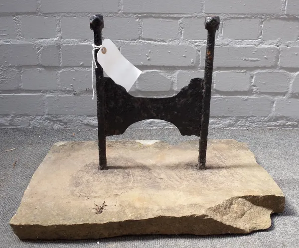 A Victorian cast iron boot scraper with canted square finials, set into a rectangular stone slab, 51.5cm wide.