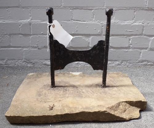 A Victorian cast iron boot scraper with canted square finials, set into a rectangular stone slab, 51.5cm wide.