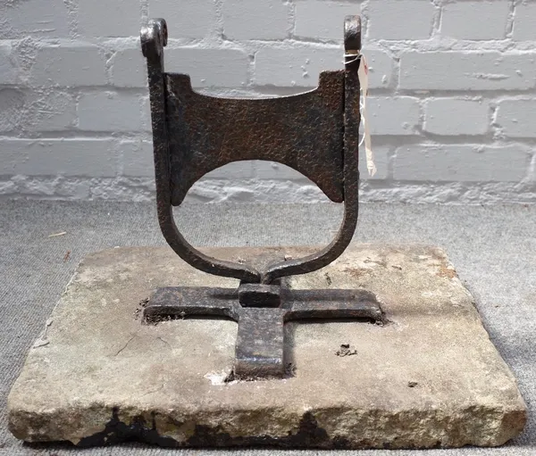 A Victorian cast iron boot scraper with scroll finials, set into a rectangular stone slab, 45cm wide.