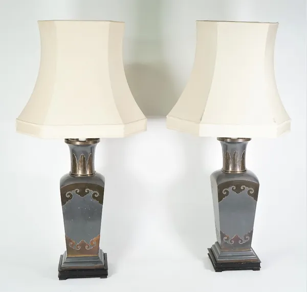 A pair of gilt metal mounted lead grey metal table lamps of Chinese style, 20th century, tapering square section on an ebonised wooden foot with cream