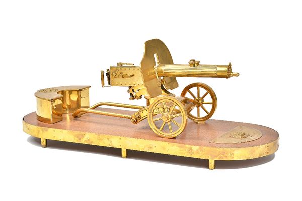 A brass desk set in the form of a Russian Maxim machine gun, 20th century, with hinged semi-circular ammunition box and brass plaque, detailed 'God sa