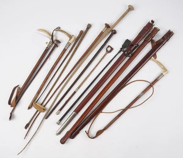 A collection of fourteen riding crops and sword sheaths, together with gun cleaning rods. (14)