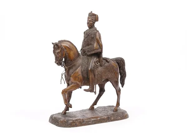 A late 19th century bronze equestrian group, cast with a Hussar mounted on his horse on a naturalistic base, un-signed, 37cm high.