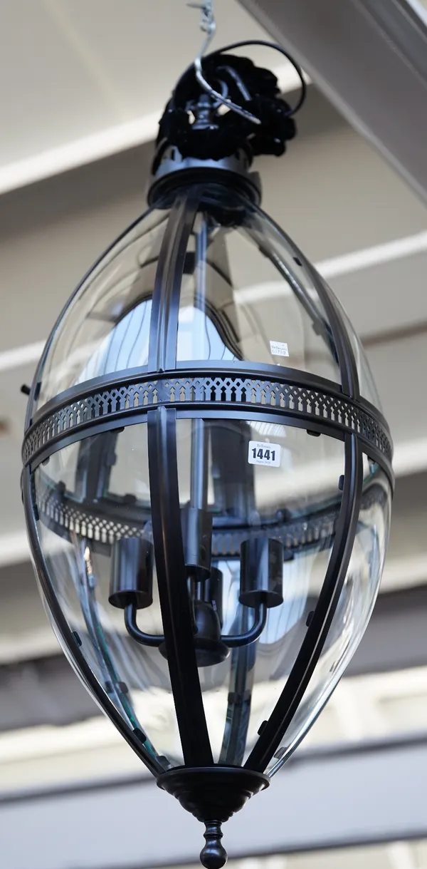 A modern patinated metal lantern of ovoid form, with glazed panels, pierced central circlet and internal four light fitment, 90cm high.