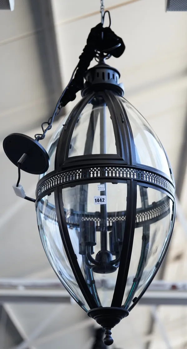 A pair of modern patinated metal lanterns of ovoid form, each with glazed panels, pierced central circlet and internal four light fitment, 90cm high.