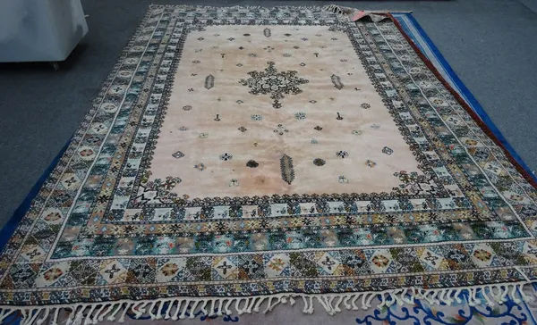 A Moroccan carpet, African, the pink field with a central medallion, minor motifs, a variety of borders, 392cm x 288cm.