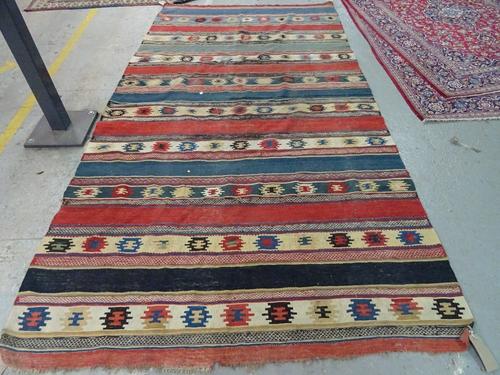 A South Persian gelim, the madder ivory and indigo banded field with stylised single motifs, 290cm x 150cm.