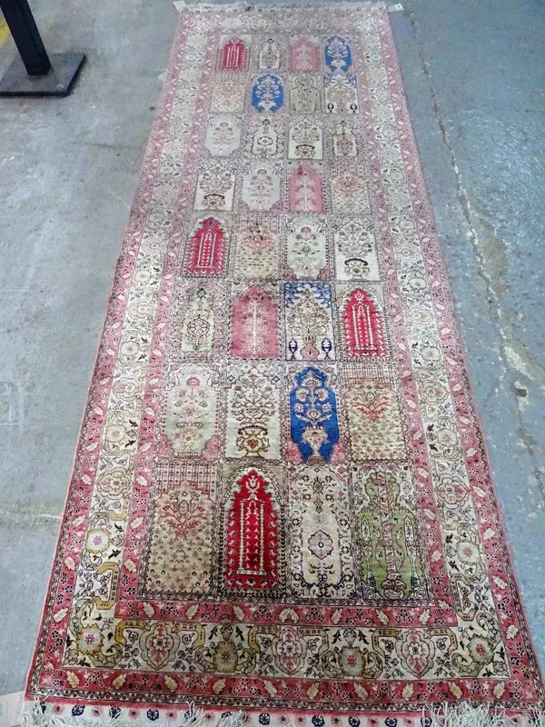 A silk Keyser prayer arch runner, Turkish, the field with eight rows of four prayer arch compartments, an ivory palmette border, 282cm x 98cm.