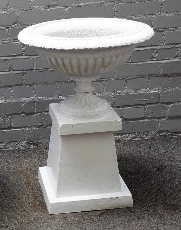 A white painted cast iron urn, on a tapering square stand, 74cm diameter x 78cm high.