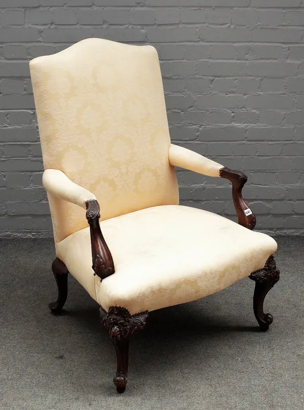 A George III style carved mahogany framed open armchair, on scroll supports, 75cm wide x 107cm high.