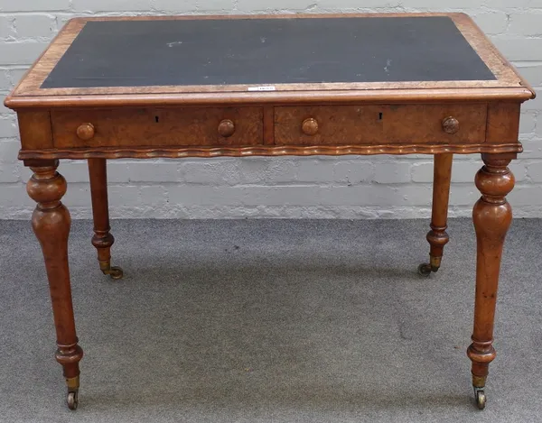 A Victorian figured walnut two drawer writing desk, with wavy frieze and turned supports, 102cm wide x 66cm deep.