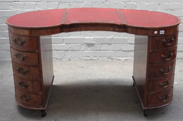 A George III mahogany kidney shaped writing desk, with angle adjustable top over ten pedestal drawers, 130cm wide x 72cm high.