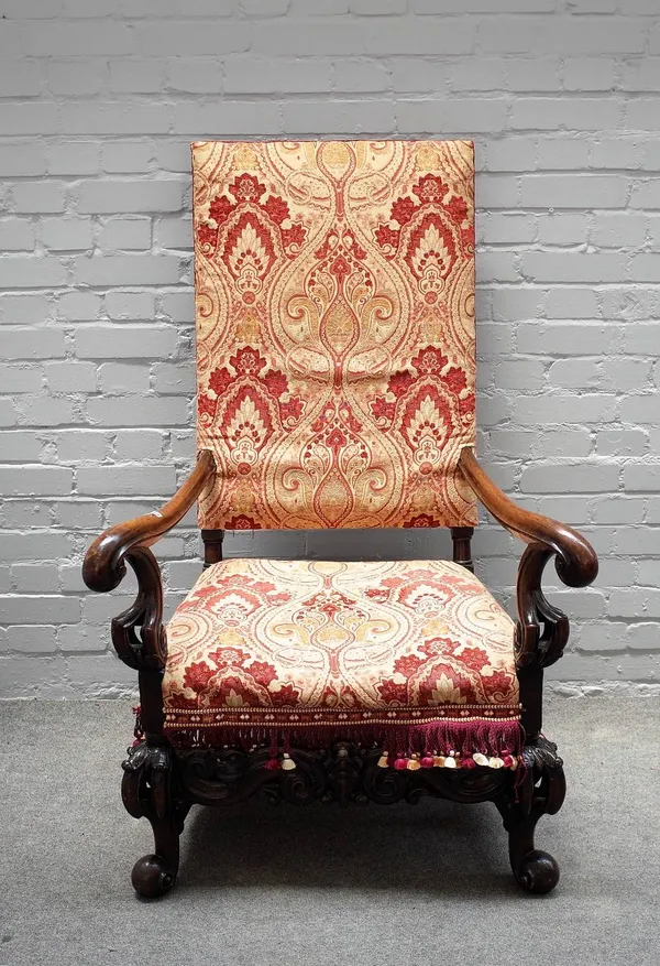 A 17th century Dutch style walnut framed square back open armchair, with carved frieze on scroll supports, 85cm wide x 129cm high.