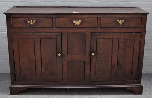 An 18th century oak dresser base, with three drawers over cupboards, on bracket feet, 151cm wide x 94cm high.