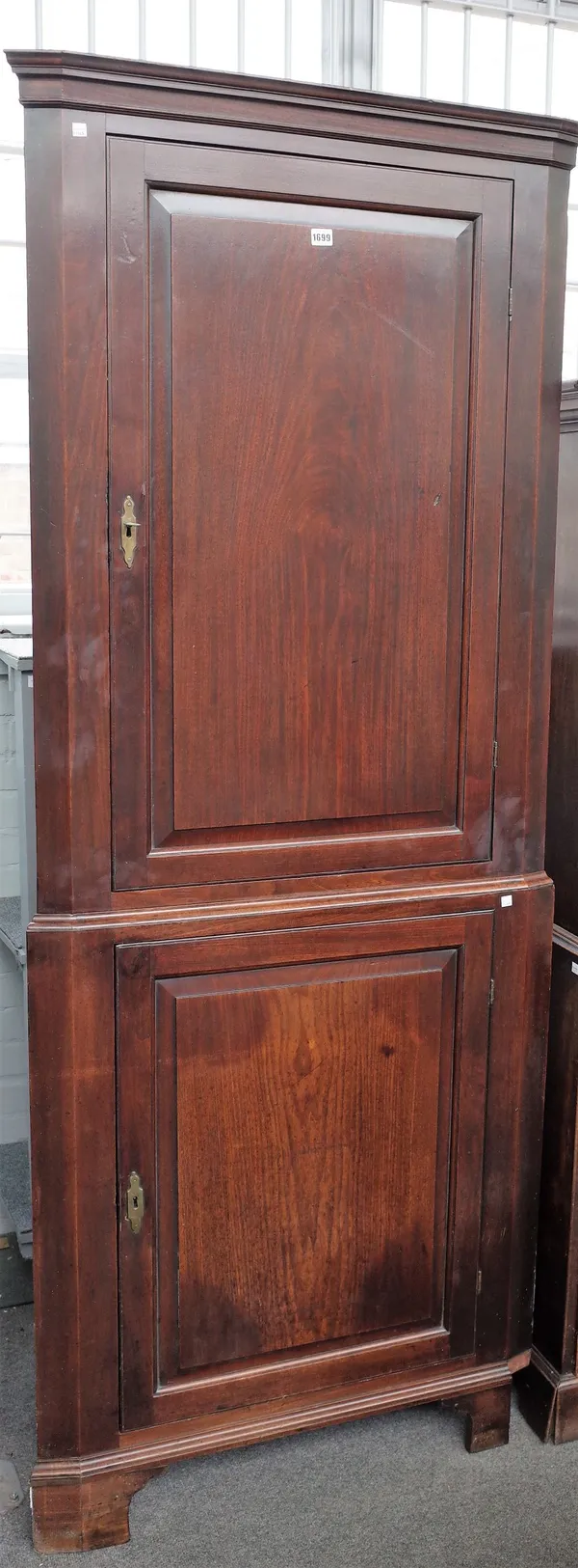 A George III mahogany double height corner cupboard, on bracket feet, 88cm wide x 213cm high.