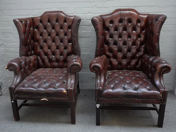 A pair of early 18th century style shaped wing back armchairs, with brown leather button upholstery on block supports, 85cm wide x 118cm high.