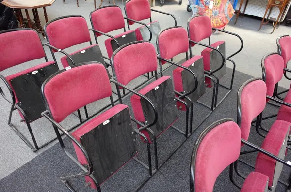 A bank of four red upholstered folding theatre seats, on black metal tubular frames, 203cm wide x 90cm high.