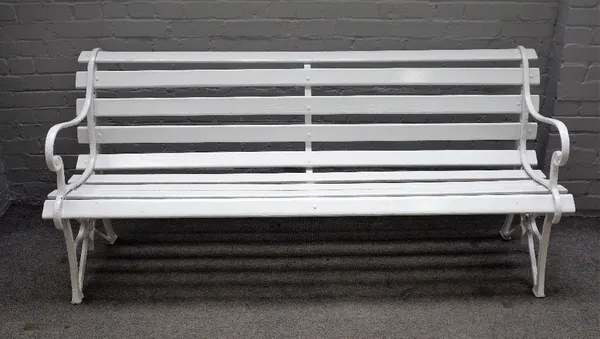 A white painted garden bench, with cast iron ends and wooden slats, 187cm wide x 82cm high.