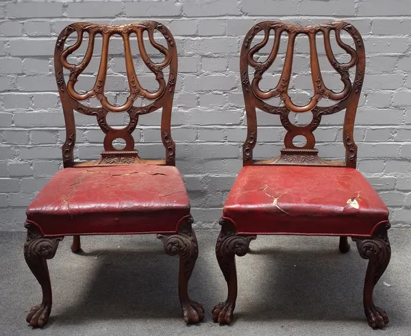 A pair of reproduction George II style walnut dining chairs, circa 1900, the foliate carved open-work backs in the form of a shell, the stuff-over sea