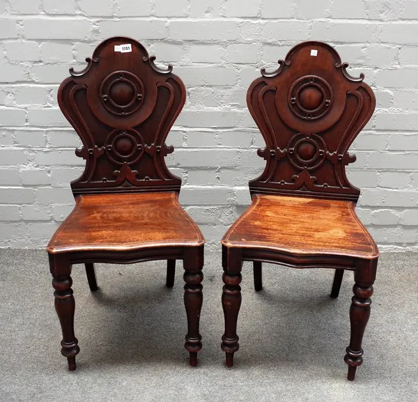 A pair of Victorian mahogany cartouche back hall chairs, on baluster supports, 43cm wide x 90cm high.