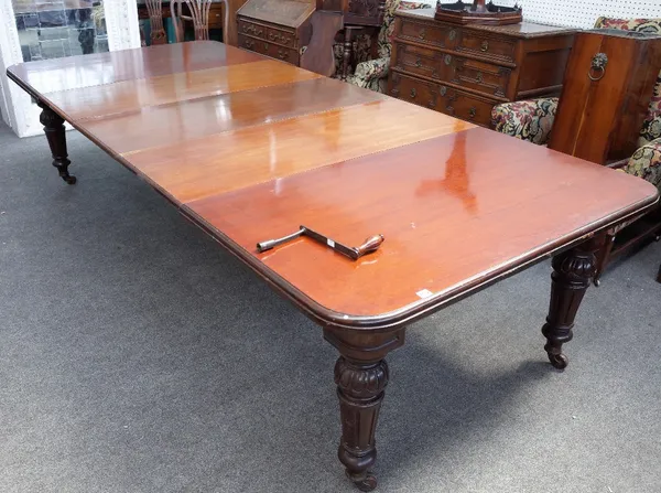 A late Victorian mahogany extending dining table, the moulded edge top with two extra leaves, on egg and tongue, turned and fluted tapering legs and c