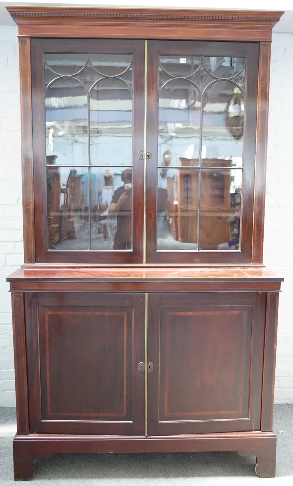 An Edwardian inlaid mahogany secretaire bookcase, the pair of astragal glazed doors, over a pair of panelled cupboards, enclosing a fitted drawer, on