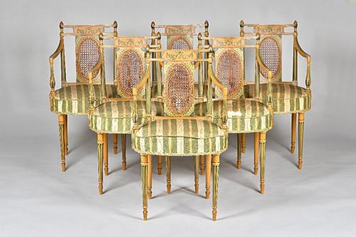A set of six Sheraton revival polychrome painted open armchairs, with cane oval panel back and circular seats, on turned supports, 51cm wide x 90cm hi