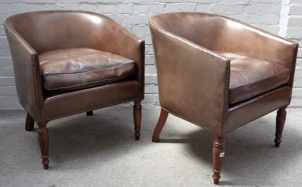 A pair of Regency style leather upholstered tub back armchairs, on turned supports, 66cm wide x 70cm high.