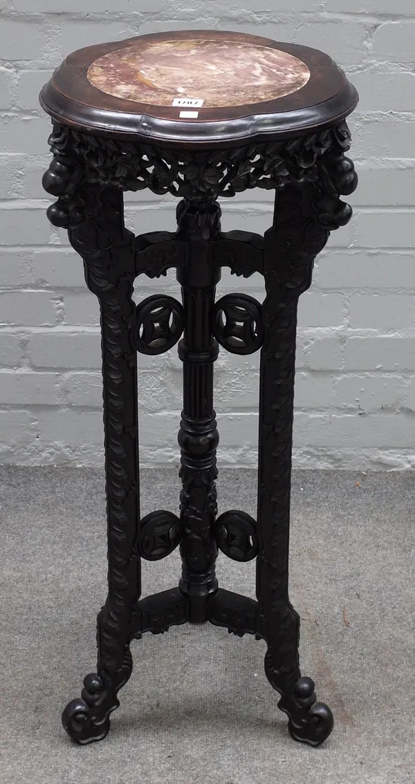 An early 20th century Chinese jardiniere stand, the shaped marble inset top over carved hardwood base, 37cm diameter x 92cm high.