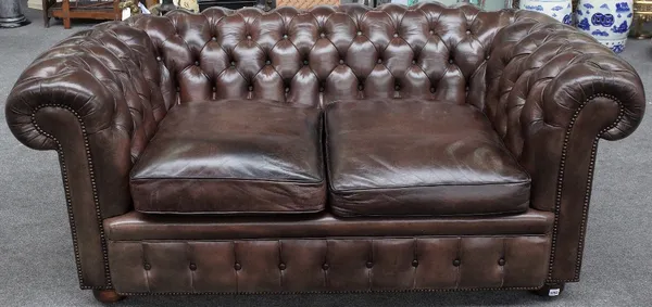 A brown leather upholstered button back Chesterfield sofa on bun feet, 175cm wide x 70cm high.