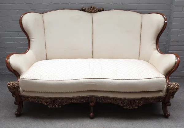 An 18th century Italian style parcel gilt mahogany sofa, with shaped back and scroll supports, 180cm wide x 99cm high.