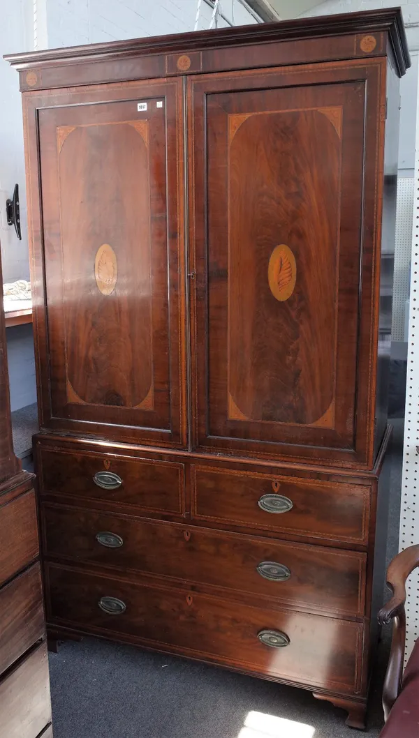 A George III inlaid mahogany linen press, the pair of doors over two short and two long drawers on ogee bracket feet, 124cm wide x 214cm high.