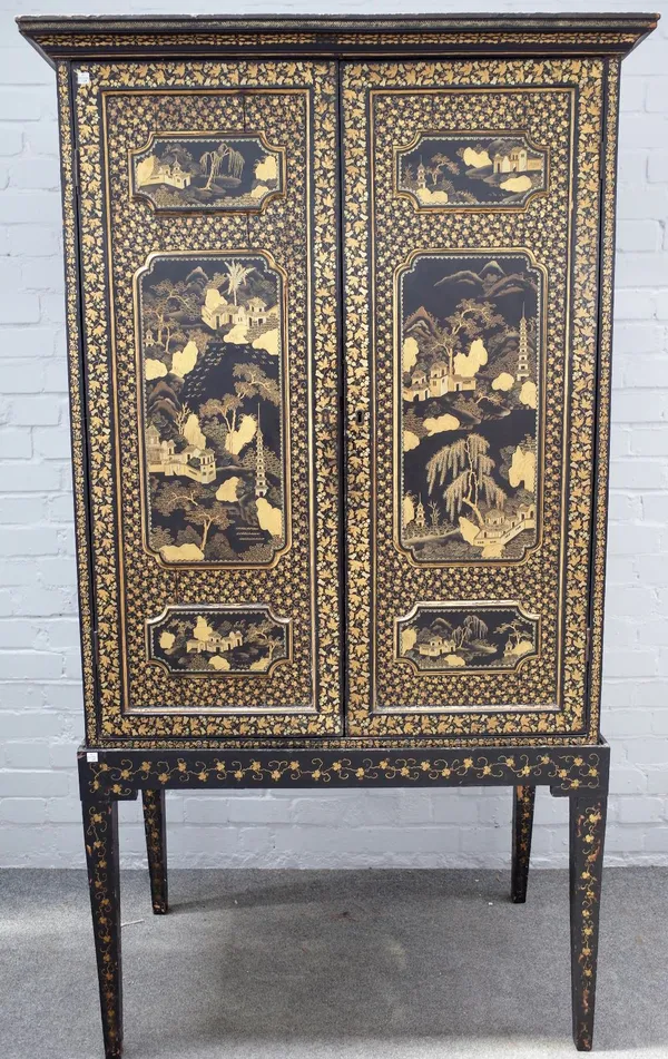 A 19th century Chinese export black lacquer chinoiserie decorated cabinet on stand, the pair of triple relief moulded panel doors enclosing a fitted i