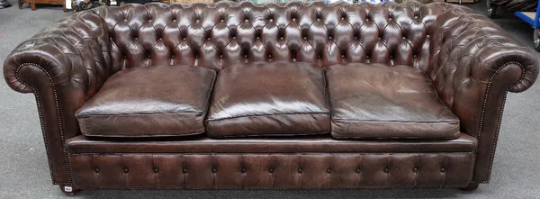 A brown leather upholstered button back Chesterfield sofa on bun feet, 228cm wide x 72cm high.