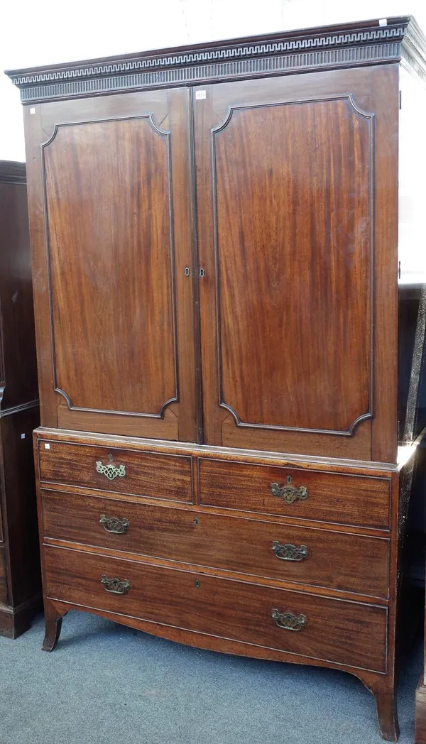 A George III mahogany linen press with a pair of panel doors over two short and two long graduated drawers on splayed bracket feet, 130cm wide x 202cm