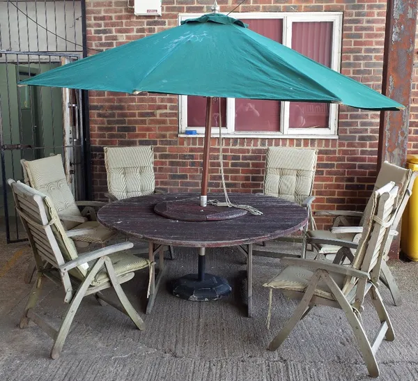 LAND OF LEATHER, a large teak circular garden table, 172cm diameter x 72cm high, together with six folding chairs and parasol, (8)