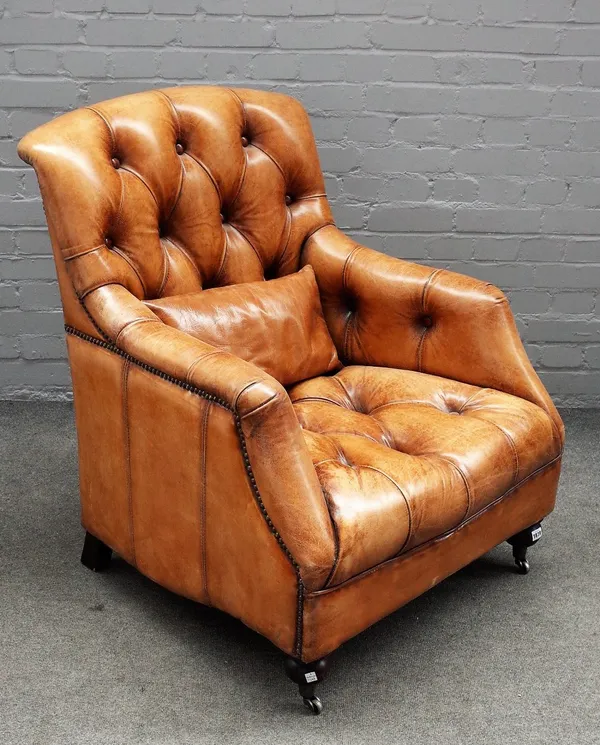 A 20th century brown leather upholstered easy armchair, on turned supports, 80cm wide x 96cm high.