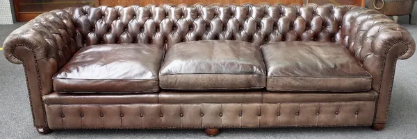 A large brown leather upholstered button back Chesterfield sofa, on bun feet, 260cm wide x 72cm high.