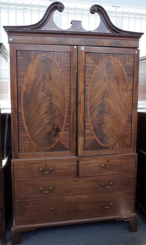 A George III inlaid mahogany linen press, the swan neck cornice over a pair of panel doors, two short and two long drawers on bracket feet, 138cm wide