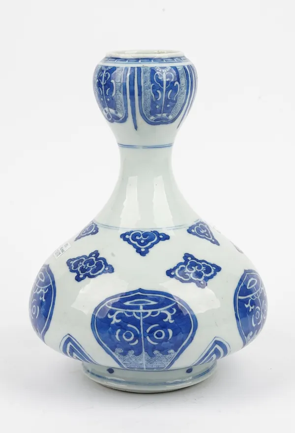 A Chinese blue and white garlic neck vase, blue Daoguang seal mark, but probably late 19th century, painted with stylised taotie masks within shaped p