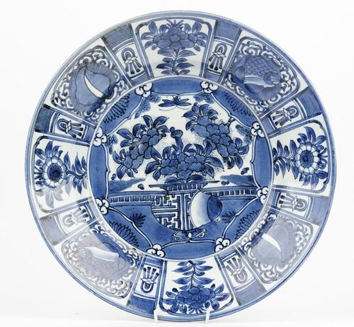 A  Japanese Arita blue and white dish, late 17th/18th century or possibly later, painted with a central vase of flowers in front of a balcony, beneath