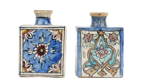 Two Qajar pottery square flasks, late 19th/early 20th century, each painted with flowers against a blue ground, one painted with fish at the ends, eac