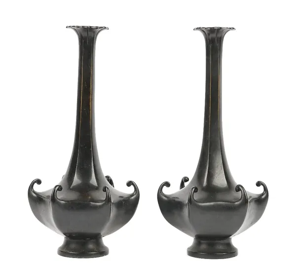 A pair of Japanese bronze hexagonal bottle vases, Meiji period, each squat body cast with scrolls at the corners, beneath a slender neck and foliate r