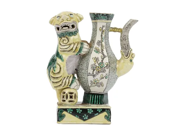 A Chinese biscuit famille-verte ewer, 19th century, the handle formed as a Buddhist lion with one paw resting on a brocade ball, 18cm high.