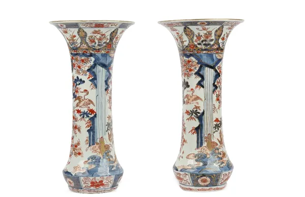 A pair of Japanese Imari trumpet vases, Edo period, late 17th century, painted in underglaze-blue, iron-red and gilding with blossoming plum, pine and