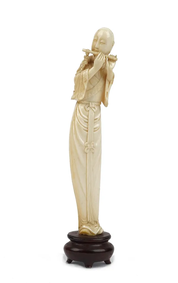 A Chinese ivory figure of a musician, early 20th century, carved standing in long robes playing a flute, 22cm high, wood base.